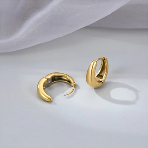 Elegant gold chunky C-shaped hoop earrings with mirror polished finish on white silk background