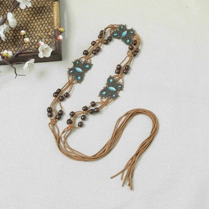 Detail of bohemian braided waist belt with turquoise butterfly metal plates and long tassels