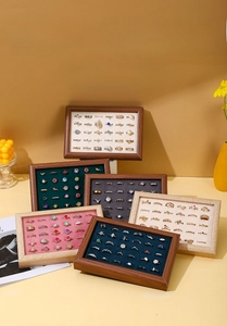 Close-up of walnut-style jewelry trays with velvet slots for ring and earring storage