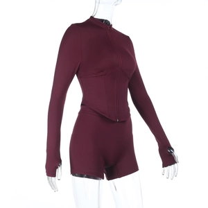 Detail of wine red yoga set with deep V zipper top and peach lift shorts for women