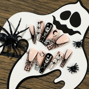 Halloween press-on nails set featuring spider webs, pumpkins, and skulls on long coffin shapes
