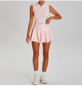 Detail of pink pleated tennis skirt and zip-up polo top with breathable athletic fabric
