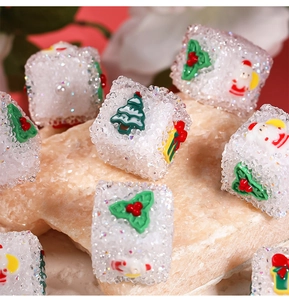 Vista macro di perle natalizie in resina glitterata con motivi di Babbo Natale
