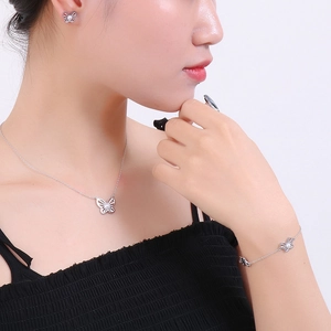Elegant butterfly jewelry set with necklace and earrings worn by model on white background