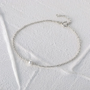 Detailed view of 925 sterling silver chain bracelet with a single round white pearl
