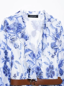 Détail de la robe à imprimé orchidée avec col en V à volants et ceinture marron à boucle