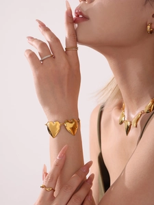 Primer plano de conjunto de collar y pulsera de corazón dorado usado por una modelo