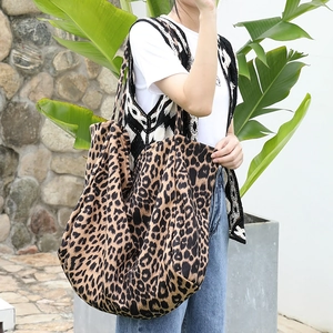 Fashionable leopard print canvas tote bag for women shown in a casual outdoor setting