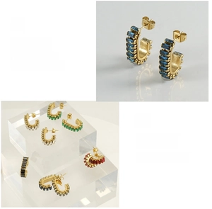 Macro detail of U-shape gold steel earrings set with multi-color baguette cut zircons