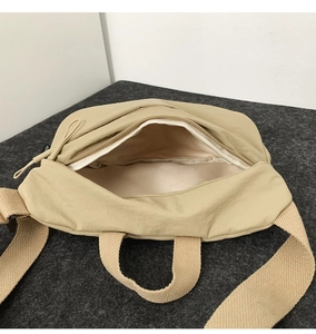 Detailed interior view of beige nylon crossbody bag showing spacious inner lining