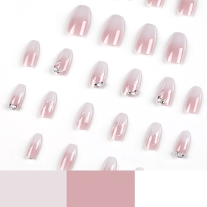 Pink and white gradient press-on nails with rhinestone and floral accents on white background