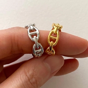 Minimalist anchor link chain rings in gold and silver finish shown on a model hand