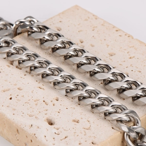 Bracelet gourmette en acier inoxydable argenté pour homme sur une surface en pierre mate