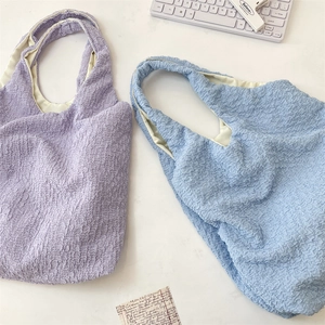 Close-up of pastel lavender and blue tote bags with distinctive bubble textured fabric