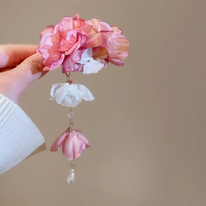 Détail de la pince à fleurs en soie dégradé rose avec papillon et glands perlés