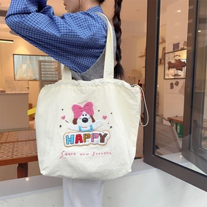 Detail of cute puppy embroidery and 'HAPPY' text on beige canvas tote bag with shoulder strap