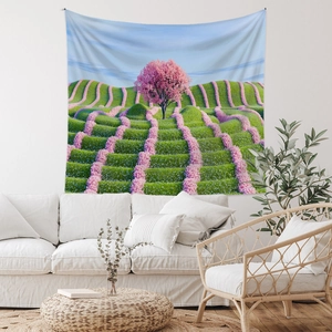 Detail of bohemian tapestry featuring a blooming pink cherry tree and green hills