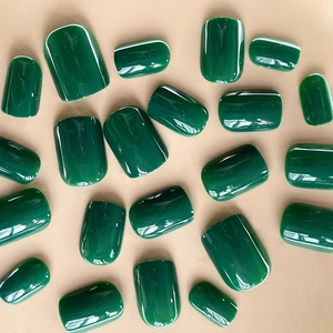 Glossy forest green press-on nails set in mixed sizes on a minimalist background
