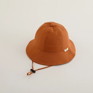 Détail d'un chapeau de soleil enfant caramel avec cordon coupe-vent et boucle réglable