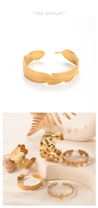 Detailed view of gold wide cuff bracelets with feather, heart and geometric patterns