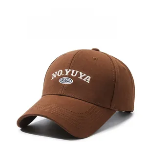 Detailed view of brown twill cotton baseball cap with white and blue embroidery