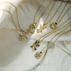 Détail de colliers plaqués or avec pendentifs chat et chien ornés de diamants