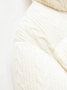 Macro shot of thick white cable knit texture showing detailed soft stitching on winter jacket