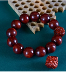 Macro view of polished sandalwood beads and intricate lion head charms on a bracelet