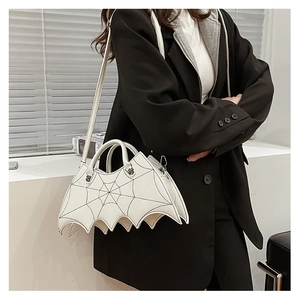 Detail of white bat-wing purse featuring black spider web embroidery and detachable strap