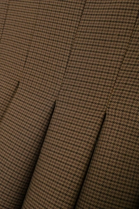 Detail shot of brown and black houndstooth pattern fabric with pleated design texture