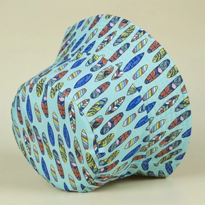 Detail of surfboard print on bucket hat featuring The Ocean is Calling text embroidery