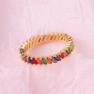 Chic gold plated ring with tilted rainbow cubic zirconia stones on pink paper