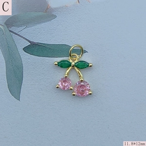 Macro detail of gold cherry pendant with pink zircon and green marquise leaves