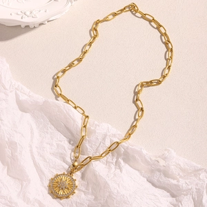 Macro detail of 18K gold plated thick chain necklace with crystal star coin pendant