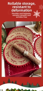 Close-up of jute Christmas placemat with red reindeer pattern and pom-pom trim detail