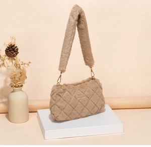 Detailed view of khaki plush quilted shoulder bag with metal zipper on display