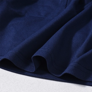Macro detail of navy blue knitted fabric showing high-quality double-needle stitching