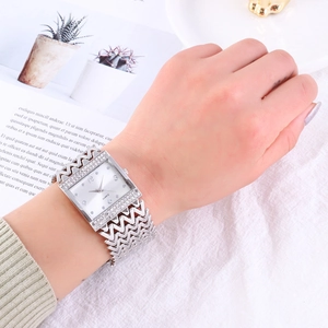 Macro shot of silver rectangular watch with rhinestone bezel and textured wave strap
