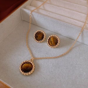Detailed set of round tiger eye stone pendant necklace and stud earrings in gold metal