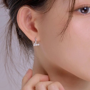 Elegant 925 sterling silver hoop earrings featuring three delicate white pearls on model