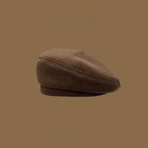 Detailed close-up of brown knit beret hat texture with Skull Studio logo detail