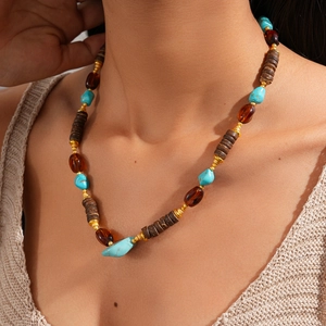 Detail of bohemian beaded necklace with turquoise stones and wooden beads on model