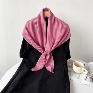 Detail of pink pleated linen-feel scarf tied in a knot on a black dress garment