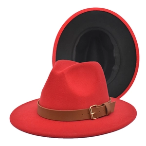 Detail of red fedora hat with brown leather belt and two-tone wool felt texture