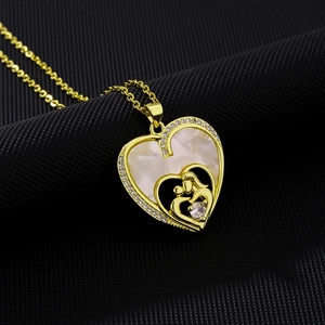 Detailed close-up of heart pendant necklace with mother and child gold relief