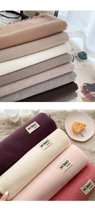 Close-up of soft cashmere-like scarves in various colors with fringe and brand labels