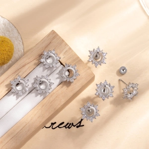 Silver snowflake ear studs made of titanium steel with zirconia on wooden display