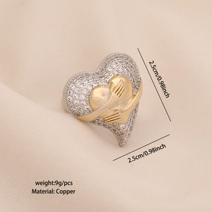 Bague cœur bicolore évidée en or et argent avec zircon sur fond de satin beige élégant