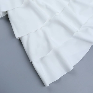 Dettaglio macro della trama del tessuto bianco multistrato di questo abito alla moda