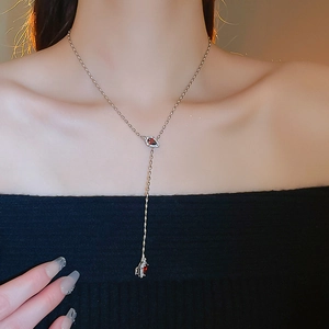 Detail of silver Y-shape drop necklace featuring red water-drop rubies and zircon accents